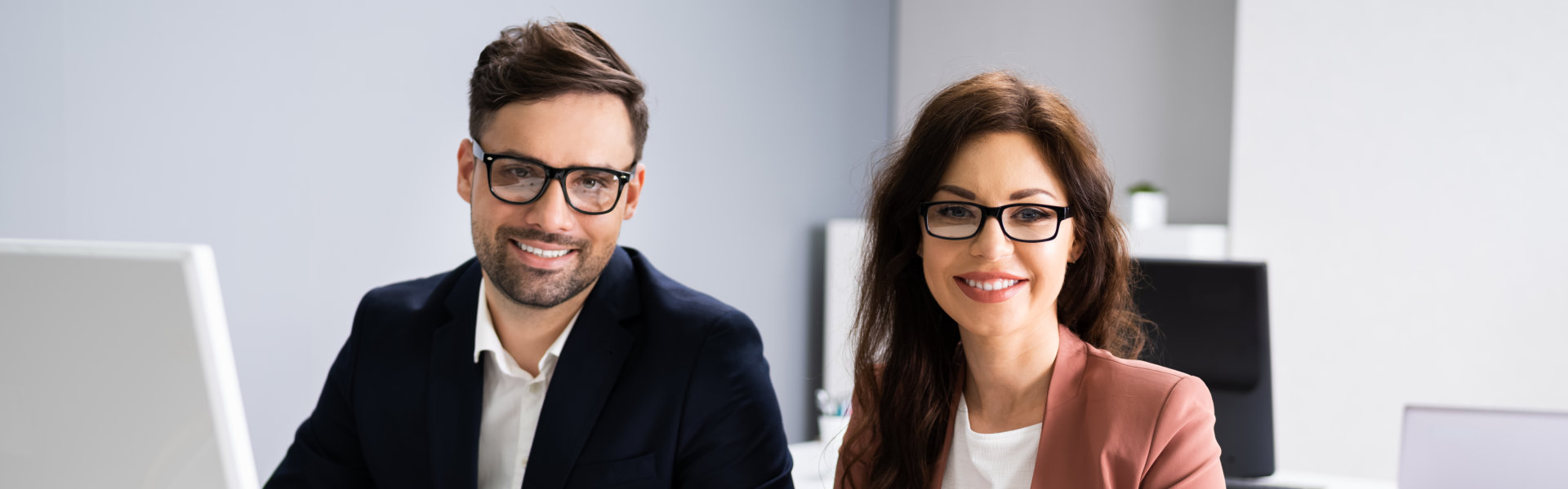 man and a woman wearing eyeglasses smiling
